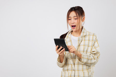 Surprised expression woman checks total on calculator and verifies it again using the same calculator, worried about the financial numbers in her budget plan. isolated studio white background TAX Dayの写真素材