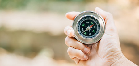 In forest a hiker relies on a compass to navigate through the confusion. compass in the traveler hand signifies leadership and exploration she maps her position and embarks on journey of discovery.の写真素材