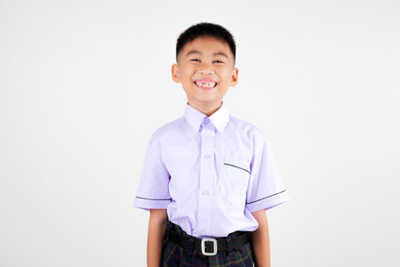 Portrait smile Asian little boy primary posing studio isolated white background, happy cute man kid wear school uniform plaid, back to school conceptの写真素材
