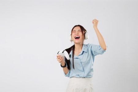 Game champion moment of a young woman celebrating play win, headphones on and her energy high from intense game experience. isolated studio white backgroundの写真素材