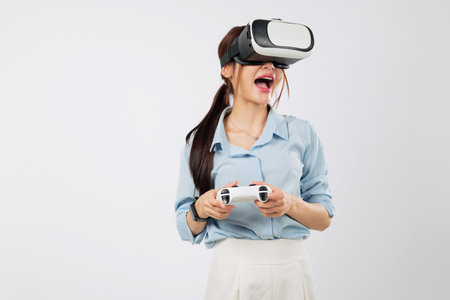 Game experience in full swing as young Asian woman enjoys VR game with console, exploring virtual reality with excitement and joy. isolated studio white backgroundの写真素材