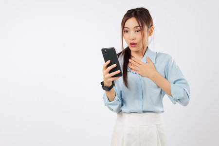 Shock asian woman look sad worry expression surprise message emotion on her phone, a young woman receives alarming news on her phone, isolated studio white backgroundの写真素材