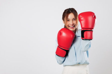 Boxing spirit and business strength blend in this smiling Asian young woman. She is ready to guard...