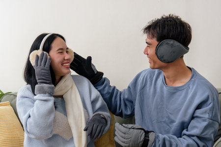 Winter day at home, happy couple, family people enjoy indoor comfort, wearing warm clothing, smiles show connection, playful interaction, cozy moment, warm atmosphere on cold winter day.の写真素材