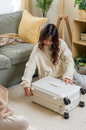 Winter friends home, young woman carefully packing home travel suitcase, friendship preparation for...