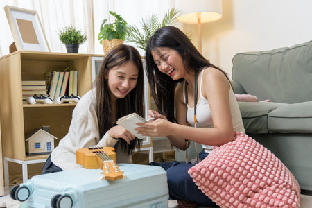 Teen friends packing bags for travel, planning exciting vacation, happily checking luggage preparation for hotel stay, discuss adventure, creating lasting memories, enjoying close friendship.の写真素材