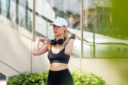 Sport woman, fit exercise, outdoor workout stretch, young people activity, wearing headphones, smartwatch, ready for dynamic urban sport lifestyle.の写真素材