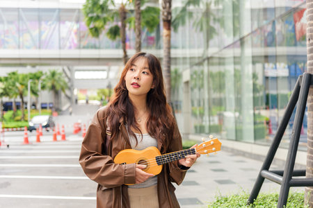 Young travel woman, happy person enjoying summer holiday outdoor lifestyle, playing ukulele on city...