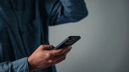 A man showing a stressed hand gesture makes a concerned pose with his phone, a bad sign for business...