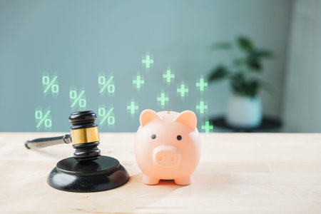 Salary compliance banking transparency legal money bank piggy save taxation concepts are shown using wooden judge gavel beside ceramic coin bank with glowing financial growth icons.の写真素材