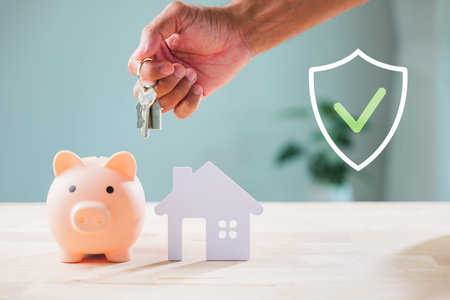 Piggy bank shows security saving, hand holds house keys, shield icon symbolizes privacy protection for major investments and future dwelling acquisition.の写真素材