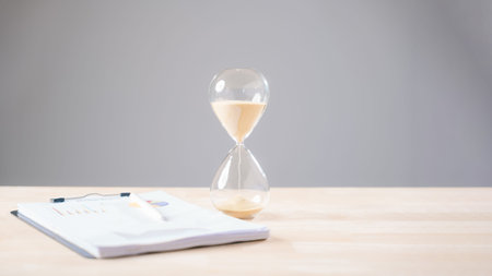 Hourglass illustrates critical time pressure for business work, important paper documents need urgent management, ensuring swift project completion.の写真素材