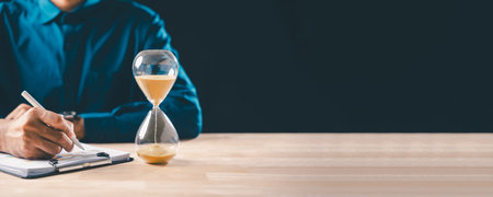 Hourglass with sand shows time passing for busy business person managing critical financial...
