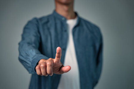 A man posing with his hand in a specific pose, a gesture or sign used for business, a focused pose...