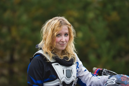 Happy biker woman with a road helmet - portrait of young mx girl, cross bike, telephotoの写真素材