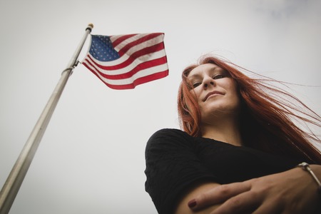 Young attractive woman in a park near flag of usa, bottom viewの写真素材