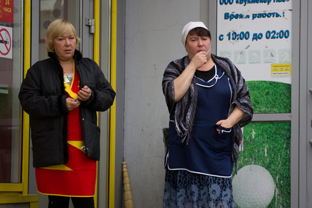 Russia, Kazan 14 september 2016, downtown - two adult russian woman clerks stand outside on the street and smokes, telephotoのeditorial素材