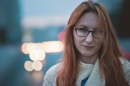 Portrait of attractive young woman with glasses, outdoor, at evening, close upの写真素材