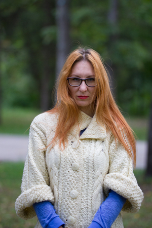 Portrait of beautiful young woman in glasses with red lips and red hair, close upの写真素材