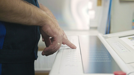 Industrial Worker. Man using industrial control panel of the Printing machine, close upの写真素材