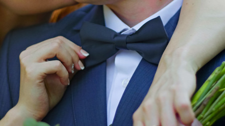 Young bride and groom are kissing in a sunny park, close up, rack focusの写真素材
