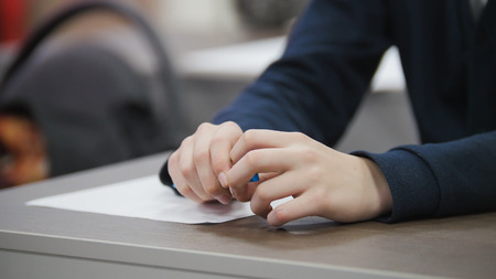 Child on school during the lesson - hands holding pen, close-upの写真素材