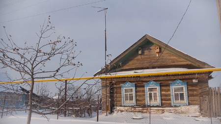 Decrepit old cottage in a snow-covered empty village in Russian, wide angleの写真素材