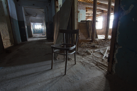 Abandoned old building - broken dusty chair in corridorの写真素材