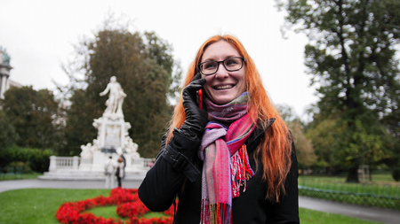 Young red hair woman using cell phone in Viennaの写真素材