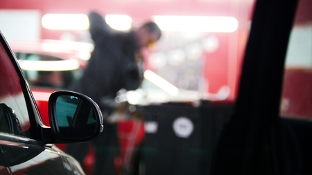 Defocused background - car service - man worker repairing automobileの写真素材