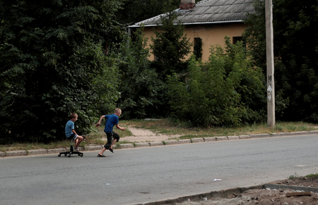 Kazan, Russia, 14 august 2011, Russian poor orphans plays with broken chairのeditorial素材