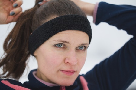 Fitness girl have work out fitness at snow winter promenade - straightens hair, close upの写真素材