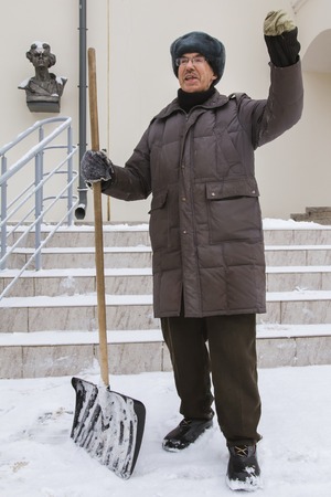 KAZAN, RUSSIA, FEBRUARY 10, 2017. The janitor in winter snow Russian street tell story about politic and salary near museum of Maxim Gorkyのeditorial素材