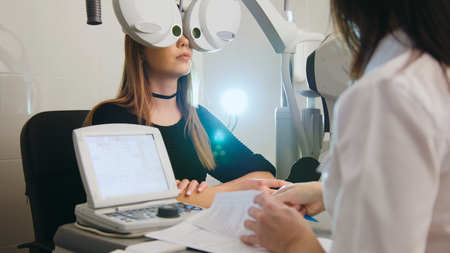 Ophthalmology - white woman checks vision in an ophthalmologist room - medicine high technologyの写真素材