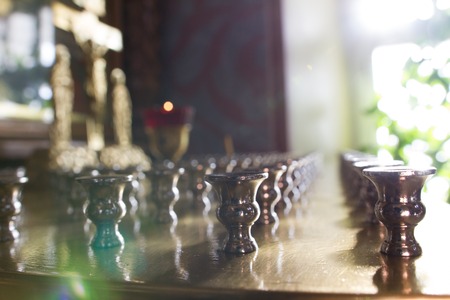 Inside Christian Church - close up view of candle holder in orthodox church at sunny dayの写真素材