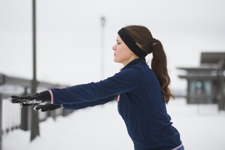 Fitness girl have work out fitness on snow winter promenade, close up