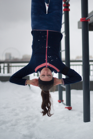 Young sport woman have strength exercises on work out fitness at snow winter parkの写真素材