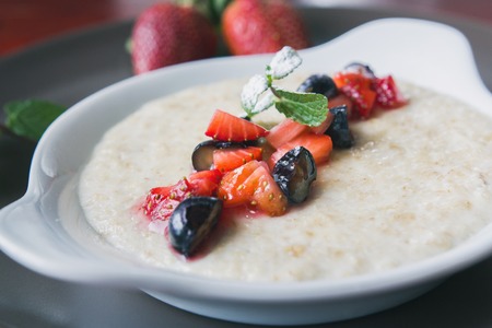 Bowl of oatmeal porridge with fruits and greens, hot and healthy food for Breakfast, macroの写真素材