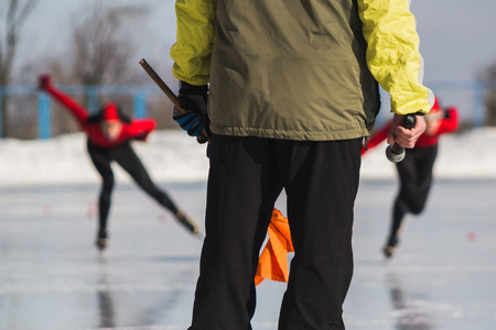 Speed skating competition - instructor and sportsmen on ice rink - childrens sport conceptの写真素材