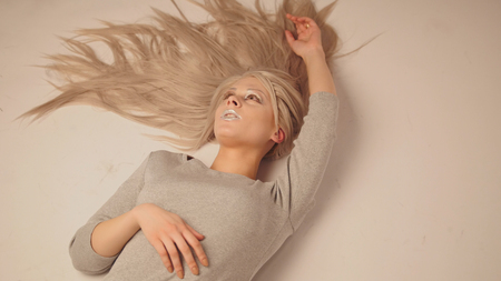 Blonde model girl lying in photo studio - close up viewの写真素材