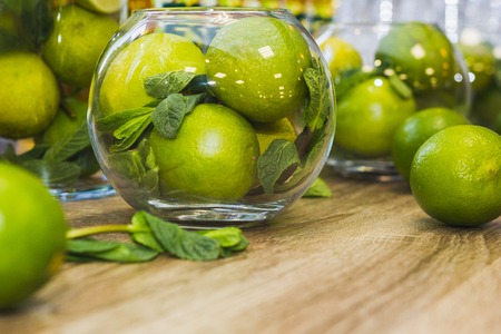 Green fruits - Limes with mint on wooden table