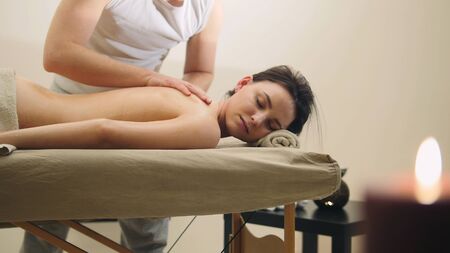 Oil relax massage - mans hands on the nude back of the black hair girlの写真素材