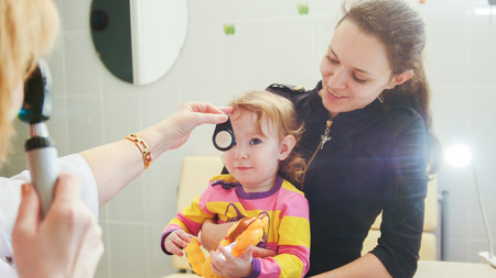 Ophthalmology - doctor checks eyesight at little girl - childs healthcareの写真素材