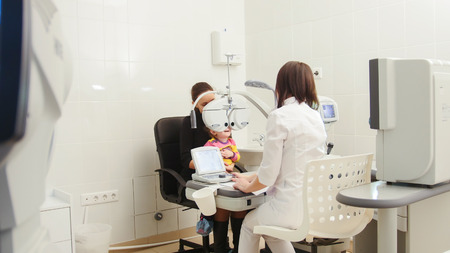 Childrens ophthalmology - optometrist in clinic checking little girls vision