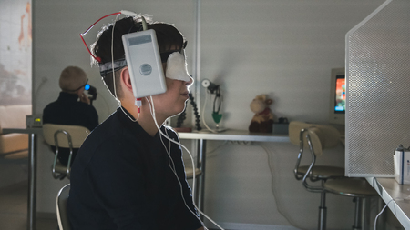 Ophthalmology clinic researching -boy with electrodes on the head looking to monitor - healthcare childrens diagnosticの写真素材