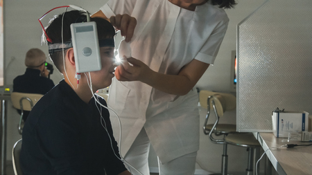 Health childrens diagnostic - optometrist female put on brain-eye equipment for boy patient - ophthalmology clinicの写真素材