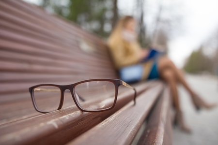 Ophthalmology lifestyle concept - glasses and de-focused reading girlの写真素材