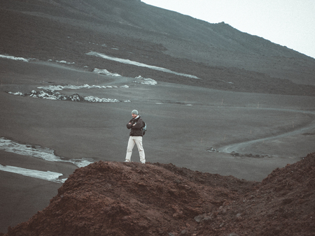 A young man travels through mountainous terrainの写真素材