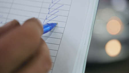Checkmark - Worker doing checking of a car parts in a garage workshop - extremely close upの写真素材