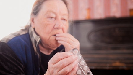 An elderly woman drinks the medicineの写真素材